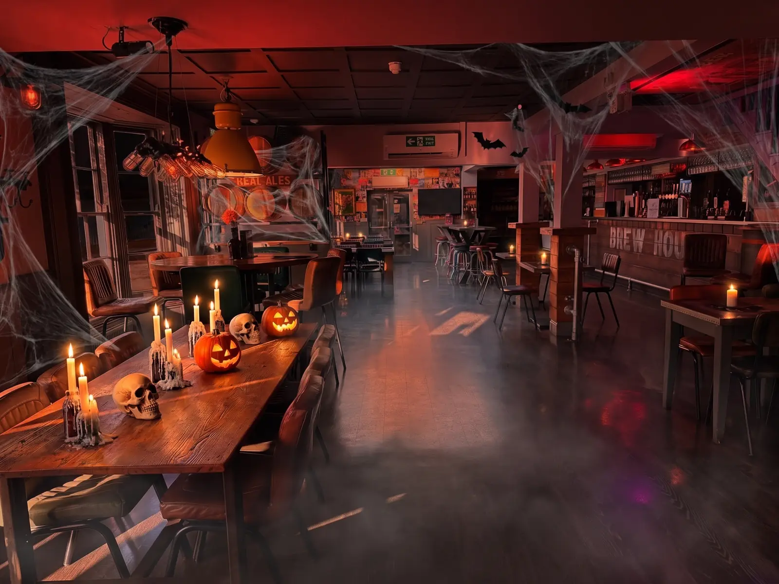 Long dining room at Fizzy Moon set for Halloween with candles and pumpkins